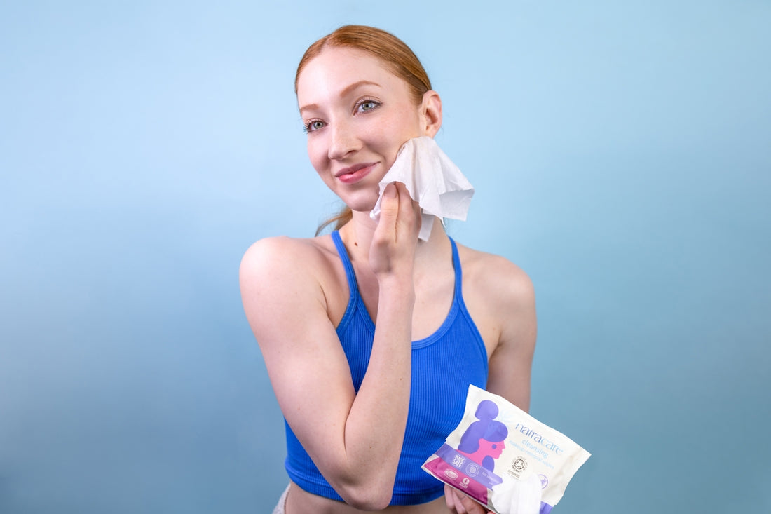 A woman in a blue tank top holding a tissue